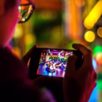 A man using a smartphone for mobile gaming, focused on the screen while playing or streaming a game.
