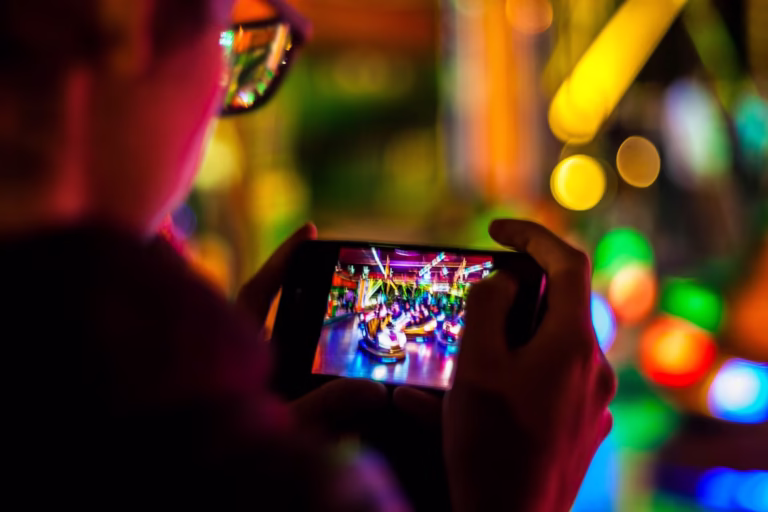 A man using a smartphone for mobile gaming, focused on the screen while playing or streaming a game.